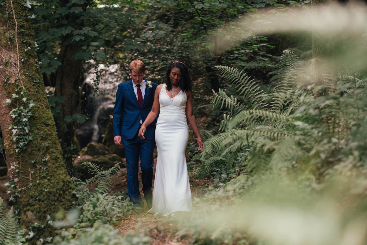 bride and groom walking through the woodland at Arnos Vale in Bristol