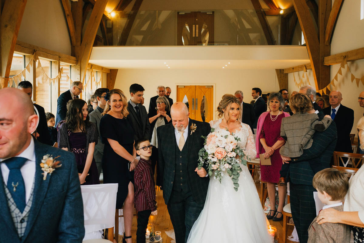 the bride and her dad walk down the aisle