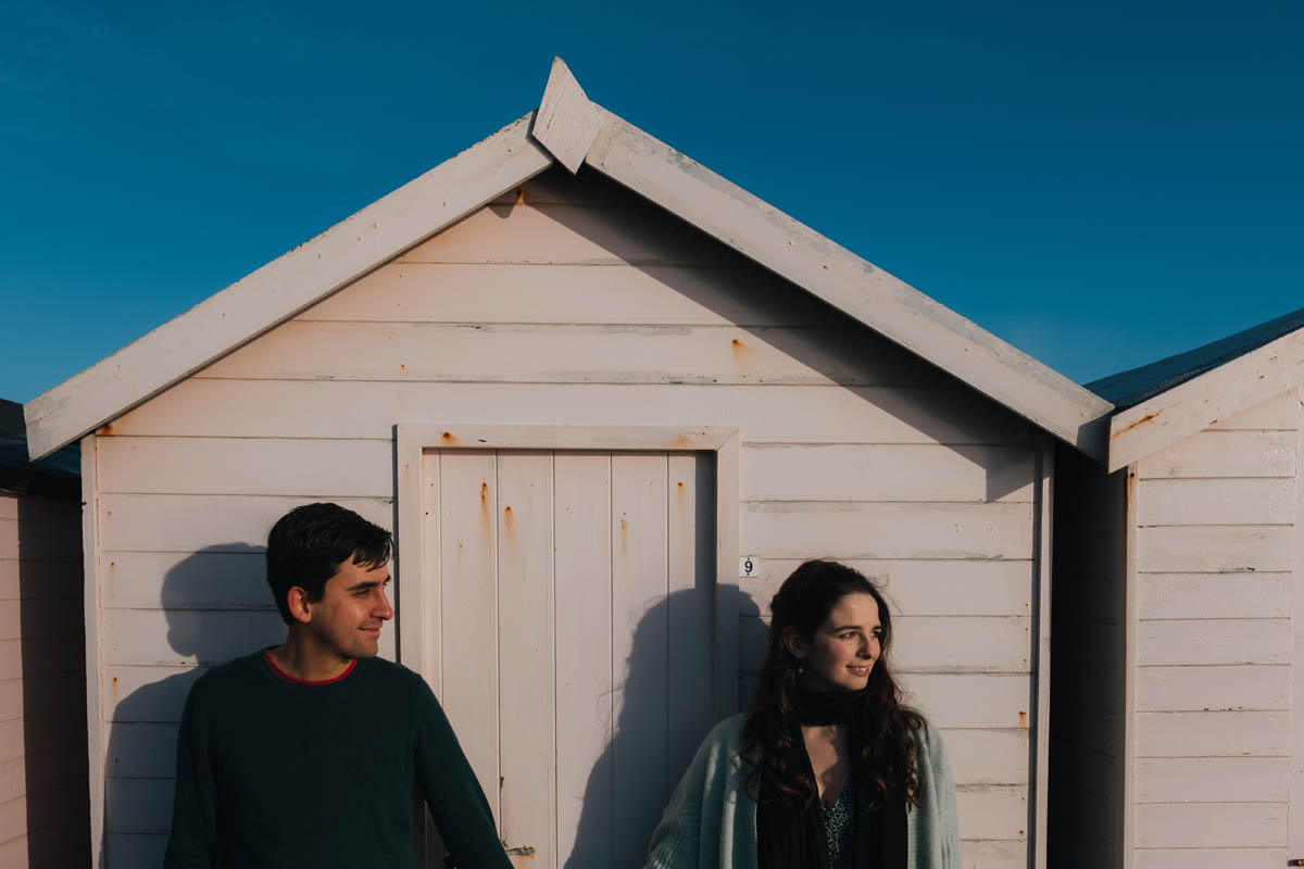 a couple look into the sun infront of a beach hut