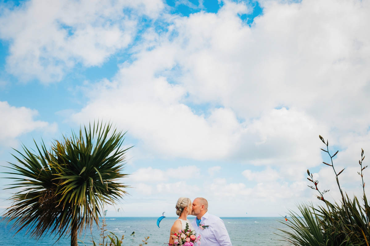 the newly married couple kiss in front of Poole beach