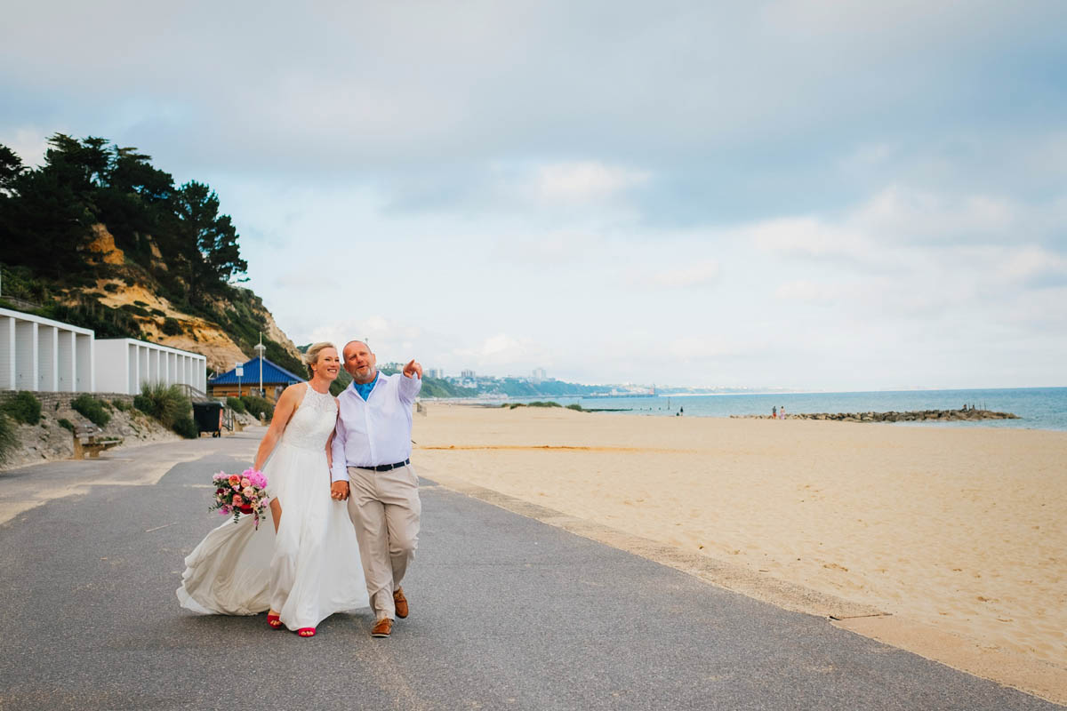 couple on poole beach in their wedding attire