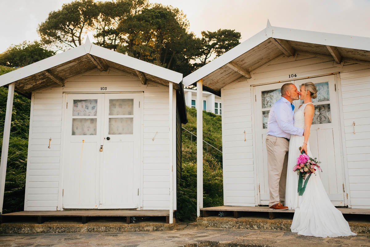 couple share a kiss on a beach hut
