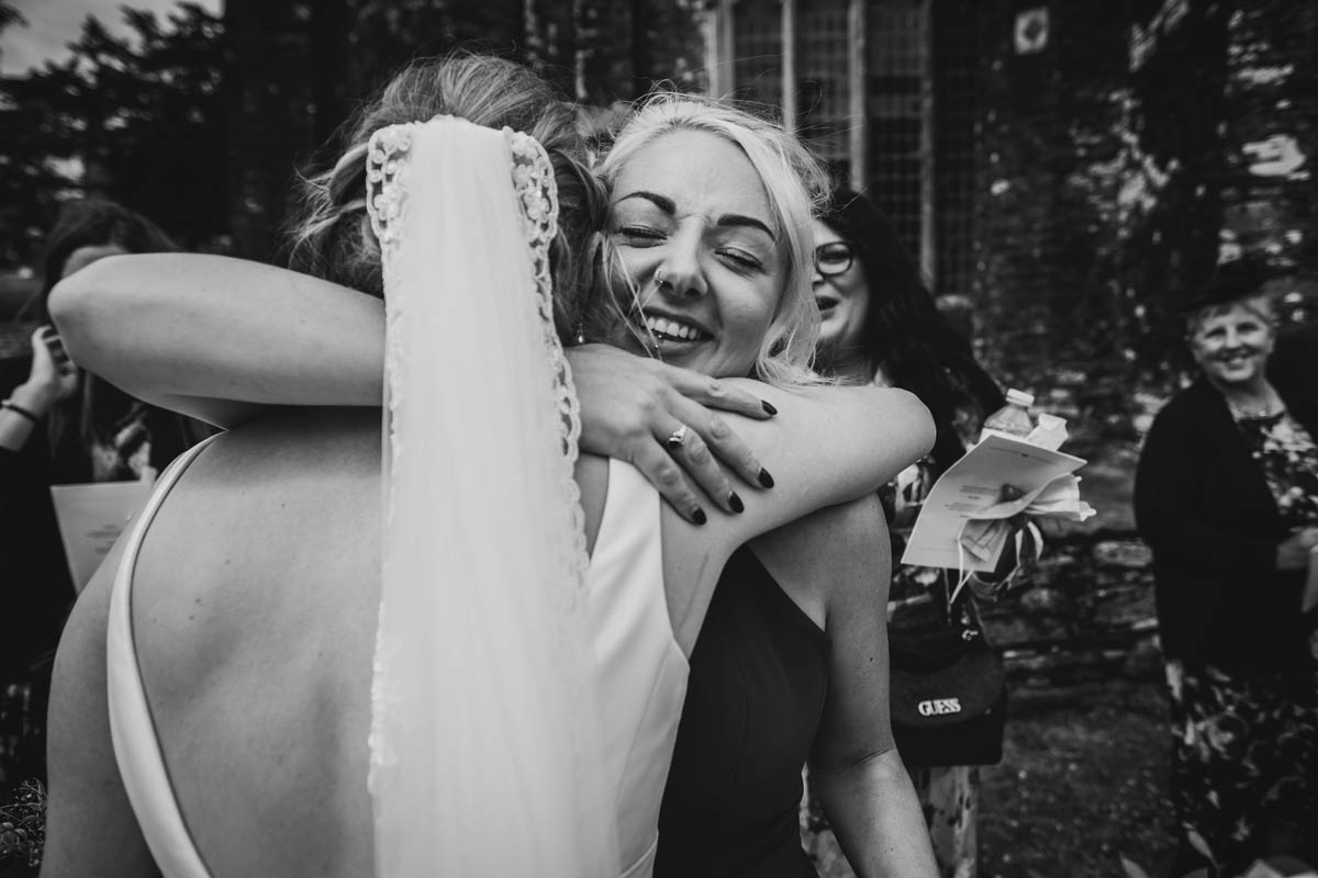 the maid of honour hugs the bride to wish her congratulations