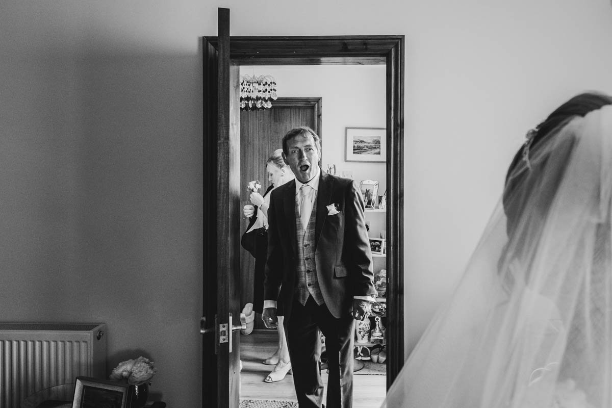 the bride's dad looks shocked as he see's his daughter in her wedding dress