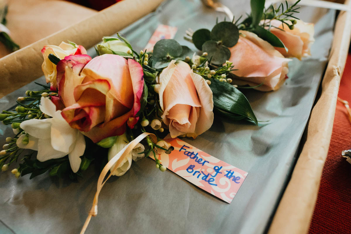 buttonholes with a label saying "father of the bride"