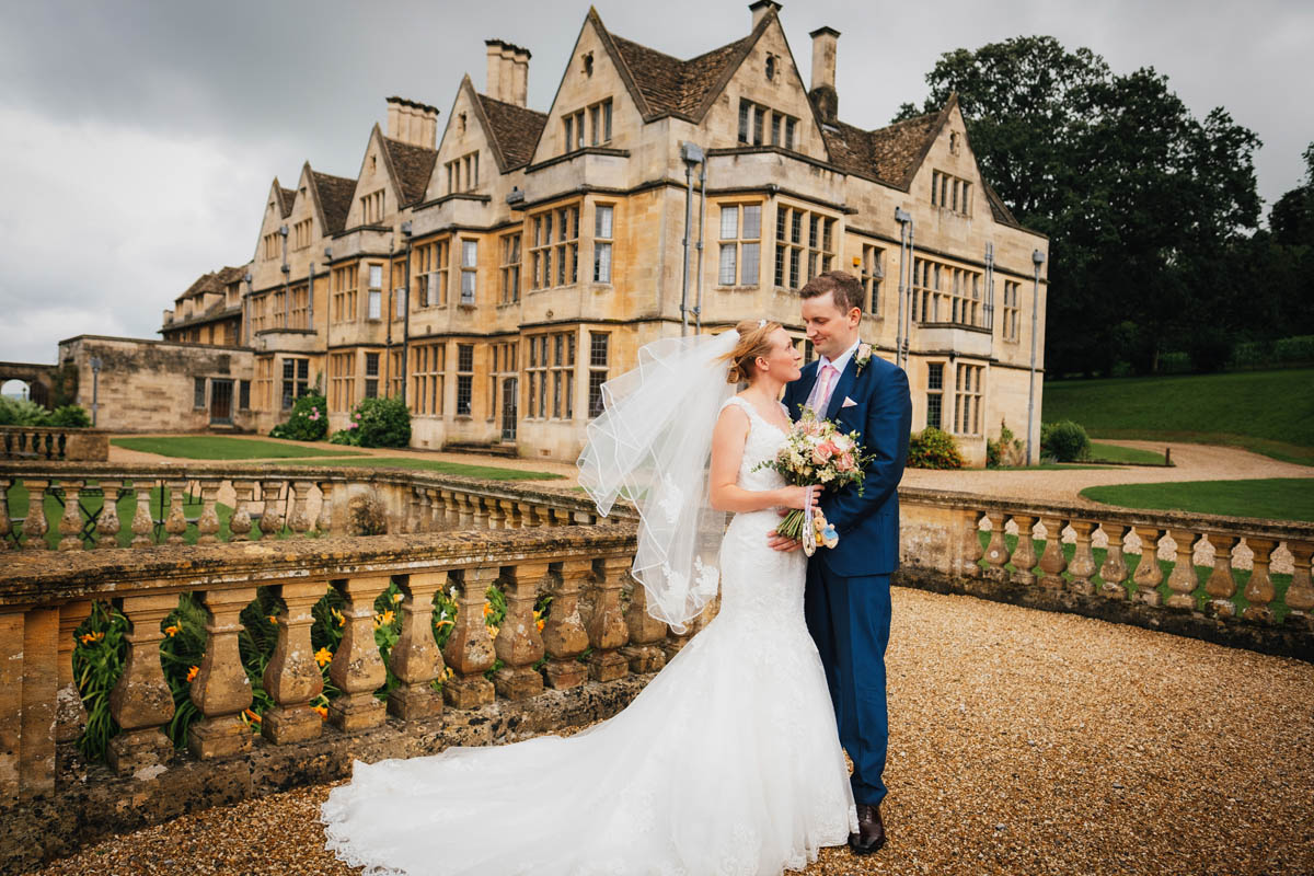 the newly weds cuddle in and look into each other's eyes outside Coombe lodge wedding venue