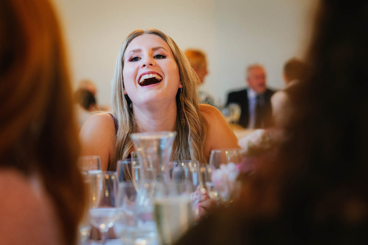 wedding guest laughing at the speech during the wedding breakfast