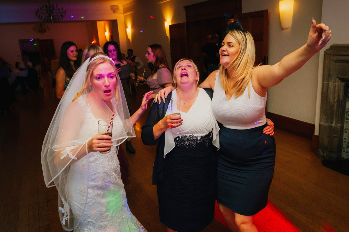 Bride and her wedding guests dance on the dance floor at Coombe lodge