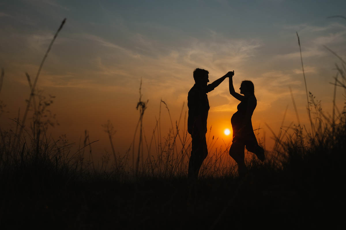 newly-engaged couple dance at sunset