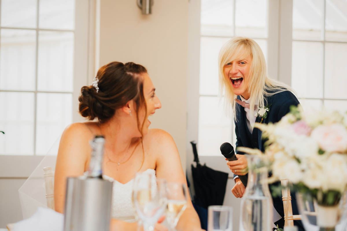 brides laugh together at the speeches