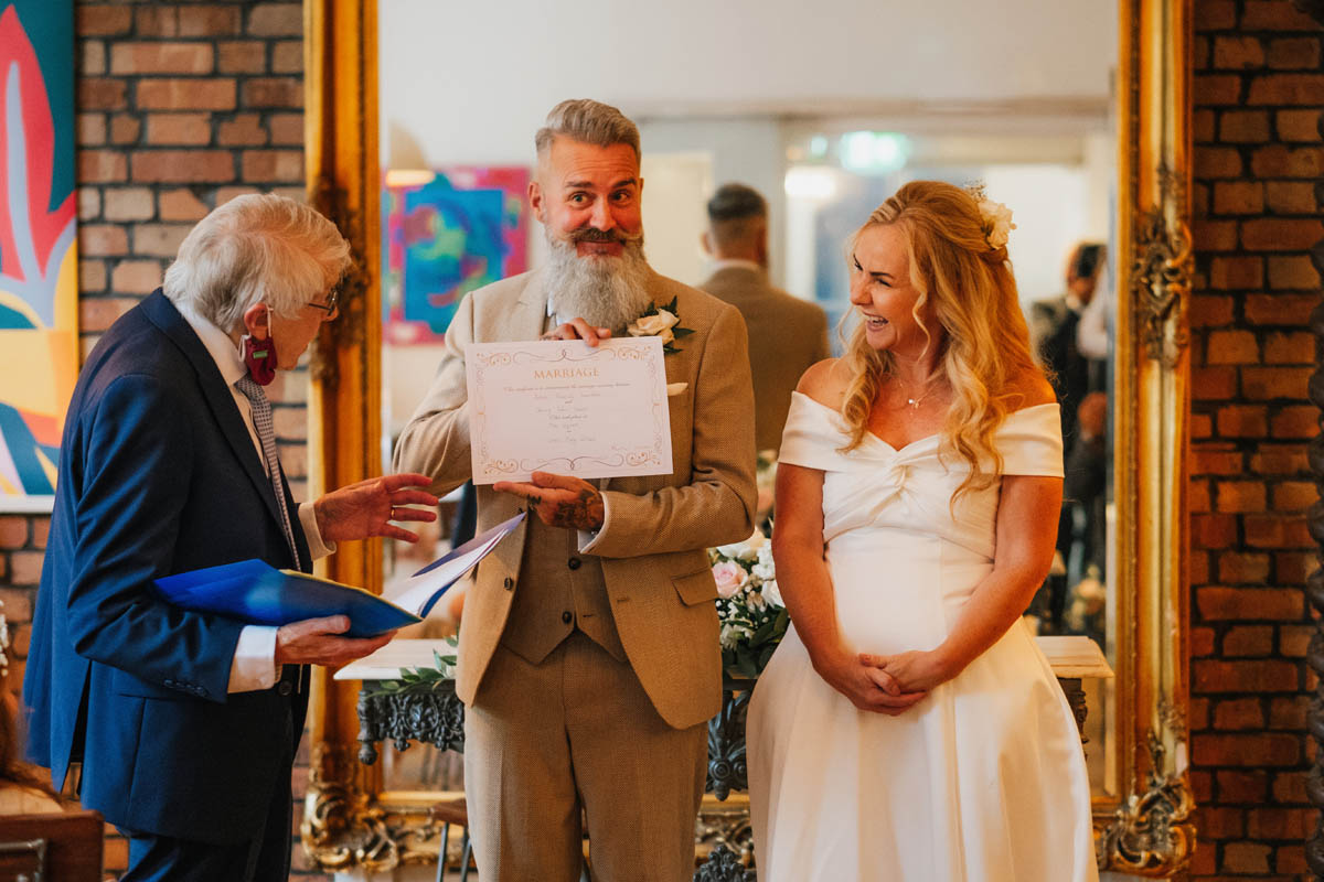 groom proudly presents his wedding certificate