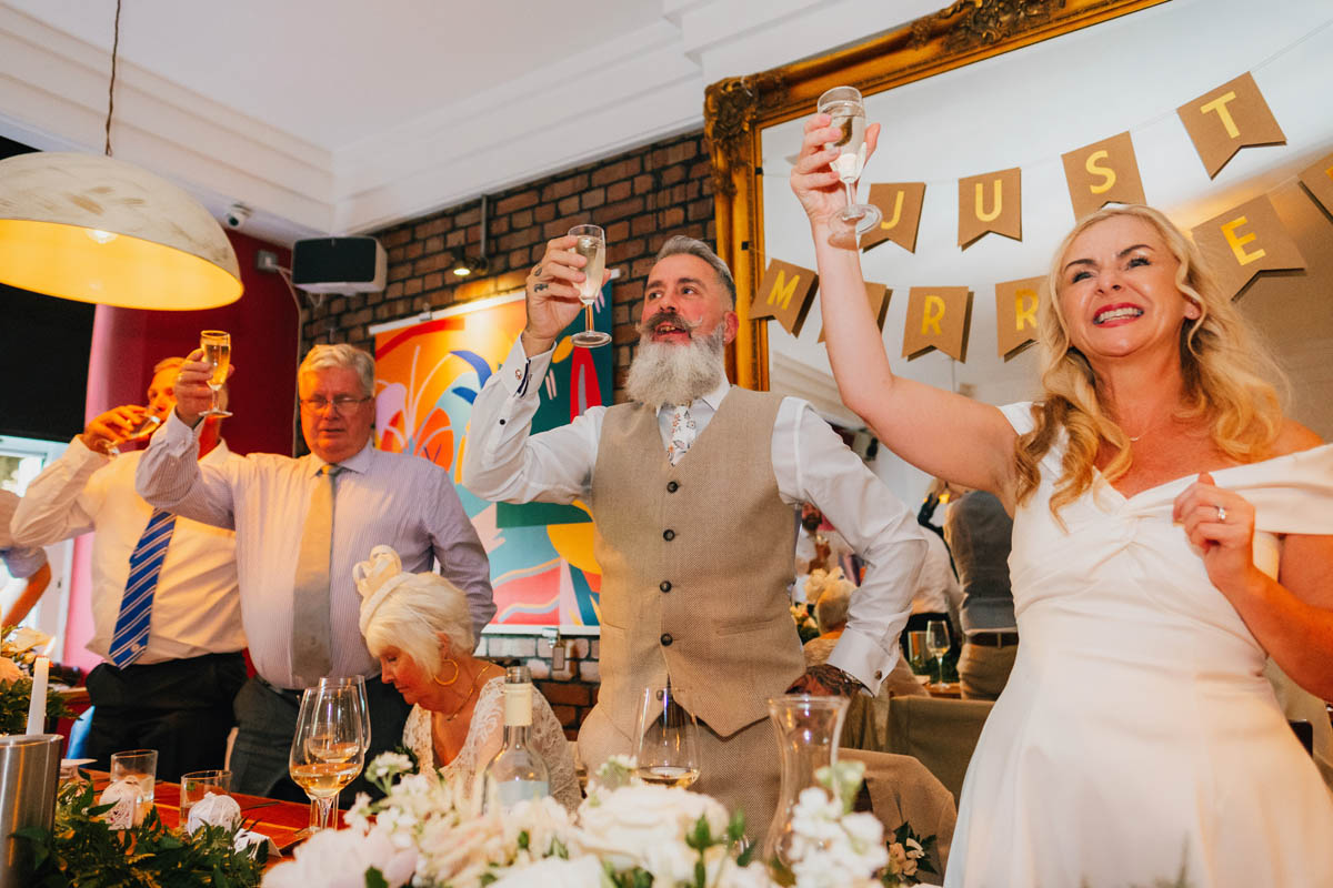 wedding guests lift glasses in a toast