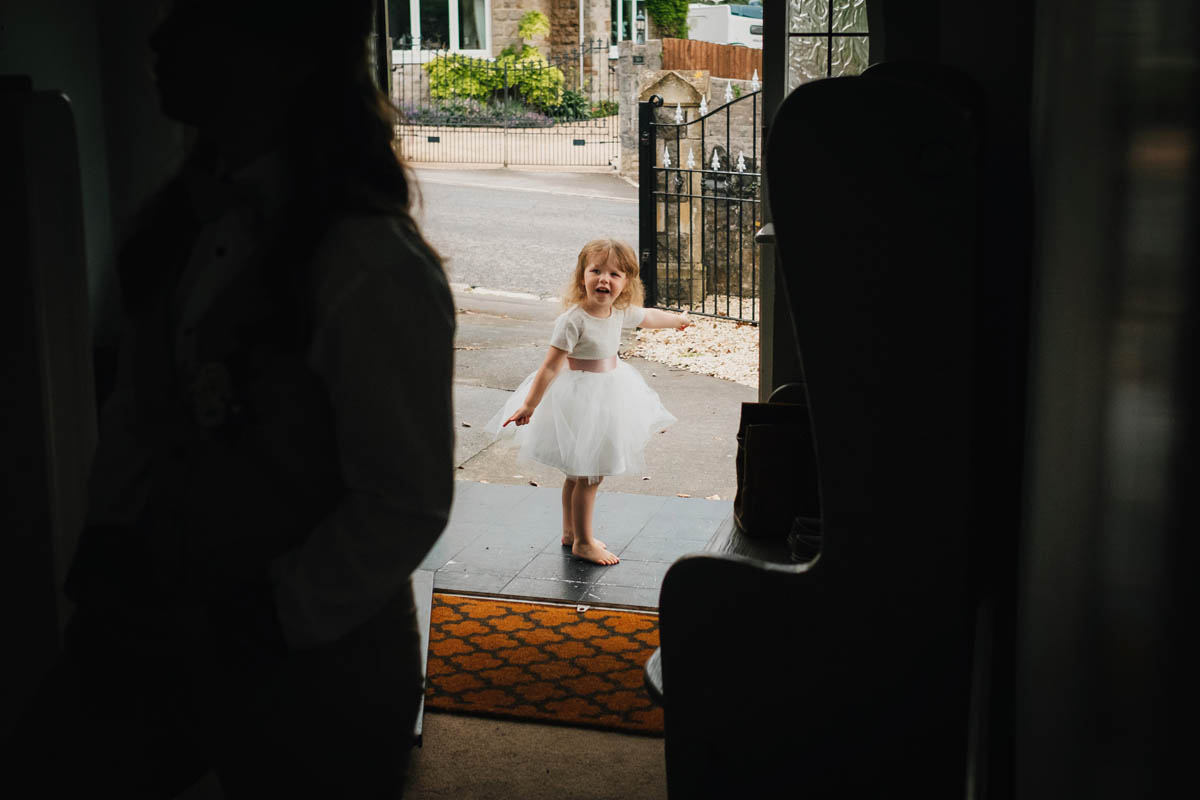 flower girl pointing to the wedding car arriving to collect the bride