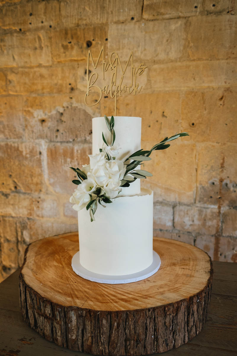 the wedding cake with log stand and flowers