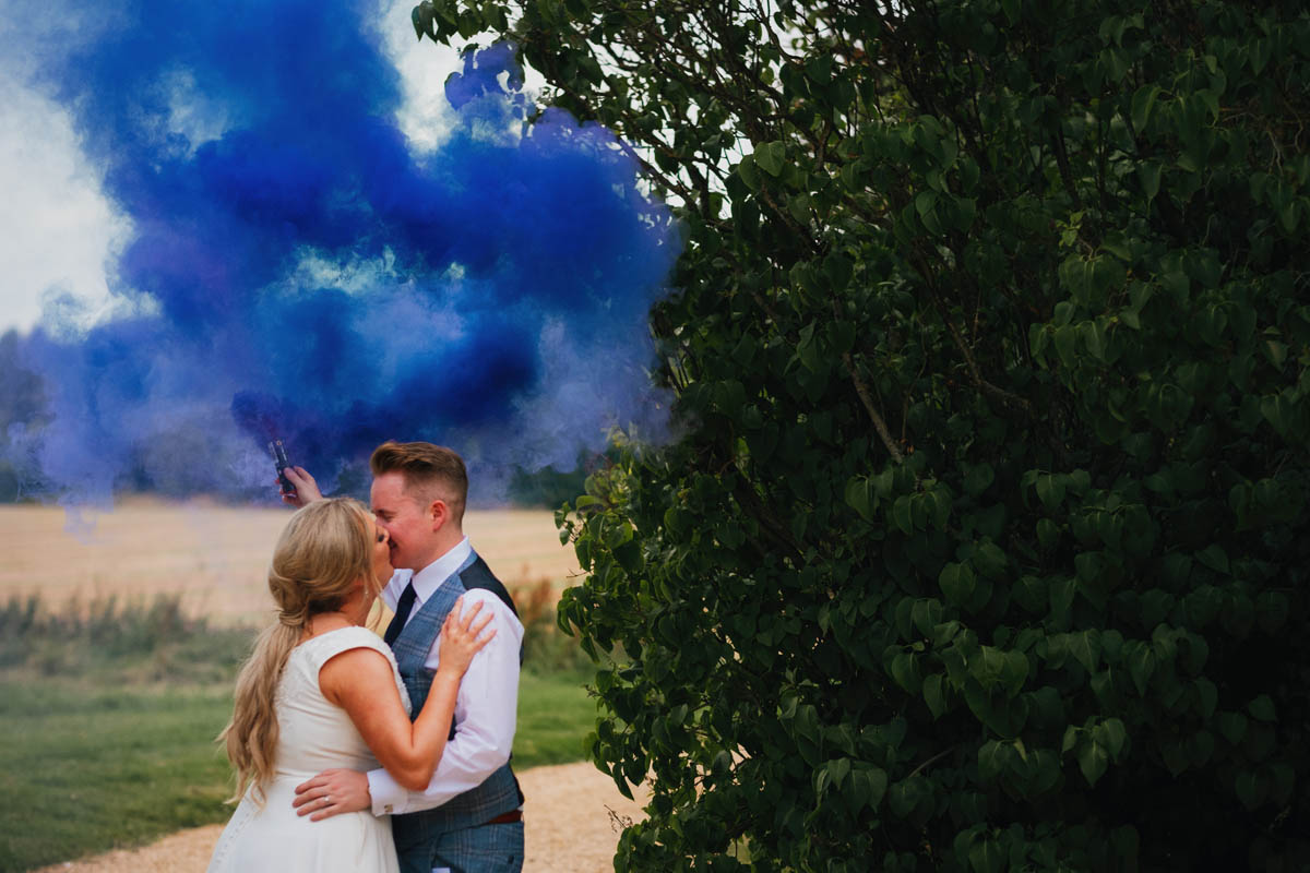 the couple kiss whilst a smoke bomb goes off behind them