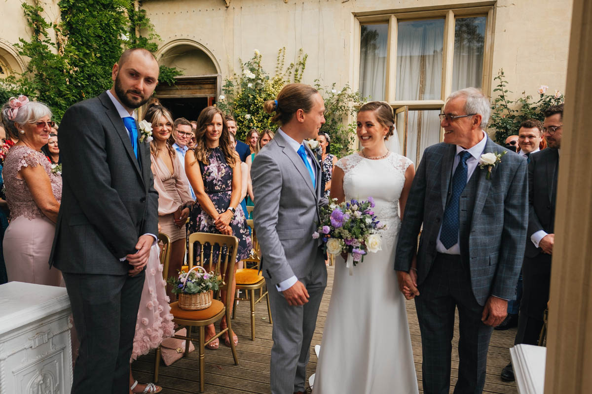 the groom greets his emotional bride as she is given away down the aisle by her father