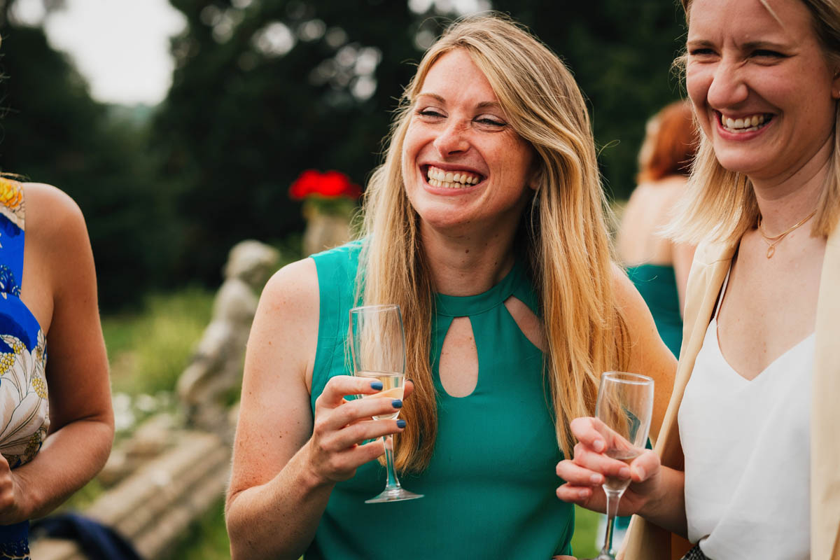 wedding guests laugh and drink champagne
