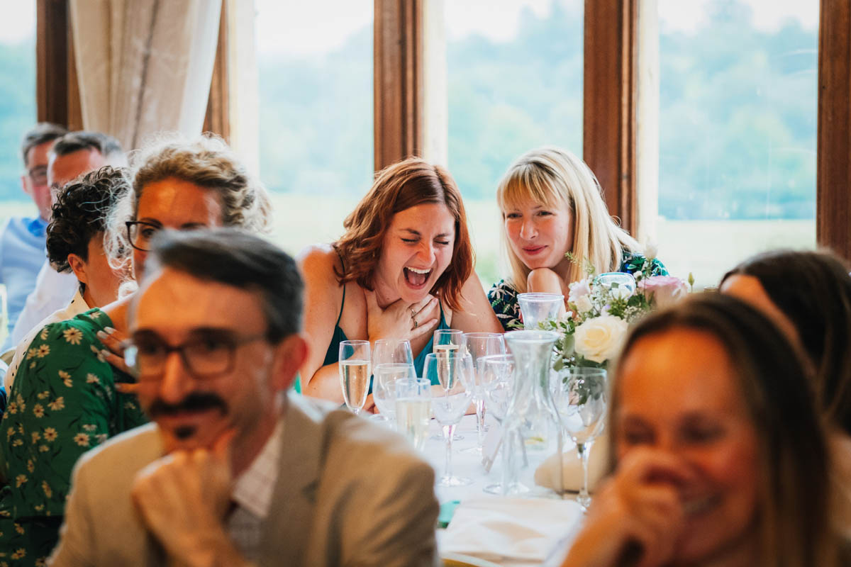 wedding guests laugh at the father of the bride's speech