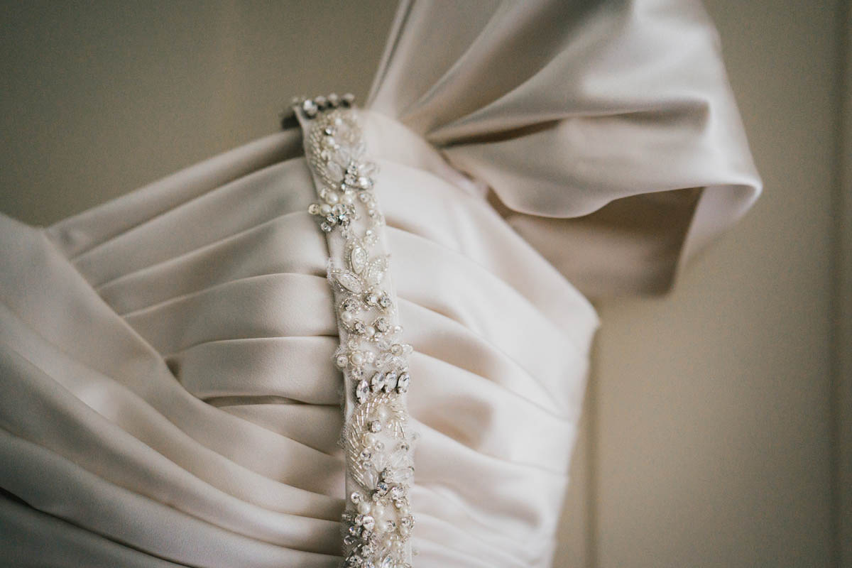 a close up detailed shot of the bride's jewelled belt and wedding dress