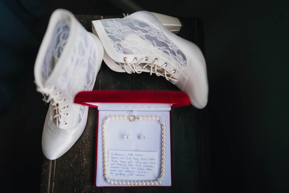 a shot from above of wedding shoes and a pearly necklace and earrings in a box