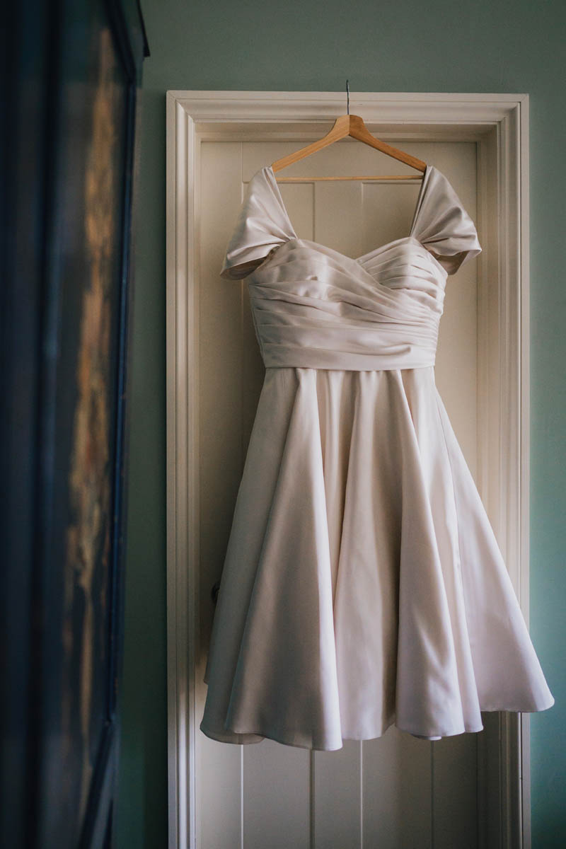 the bride's gown hung up in a doorway