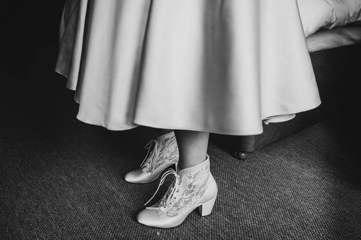 black and white image of the bride's dress and lace ivory heels