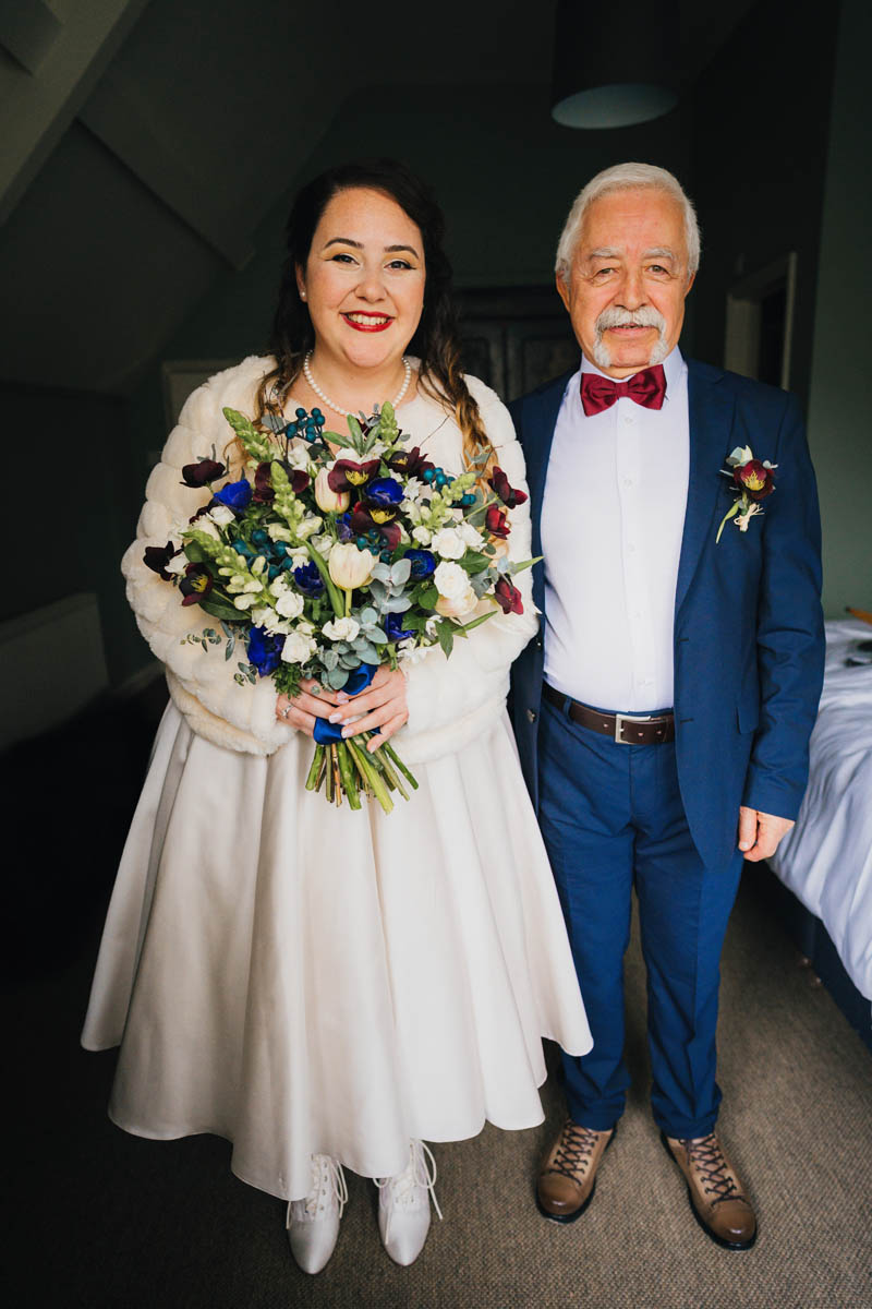 a portrait photo of the bride and her father in their wedding attire