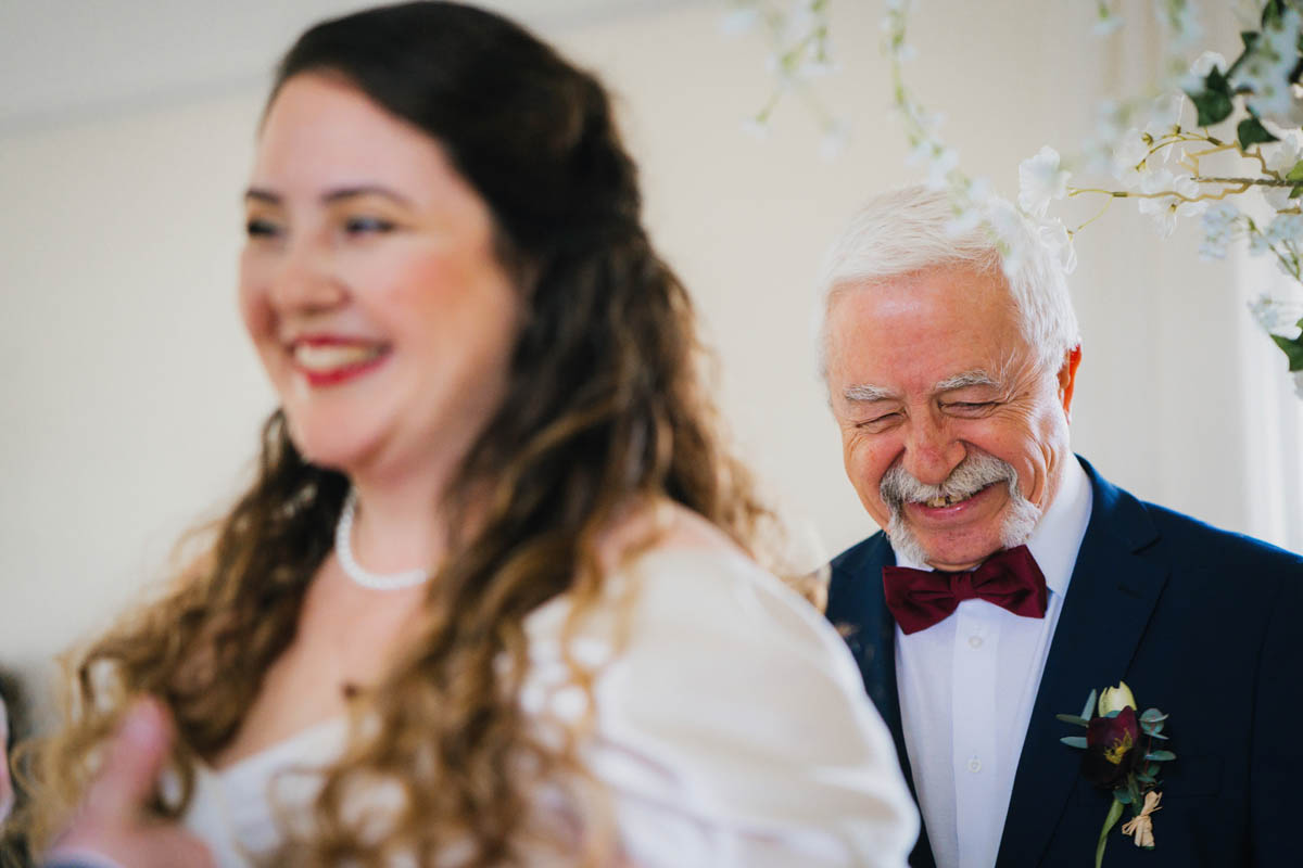 the bride's father laughs as he gives away his daughter