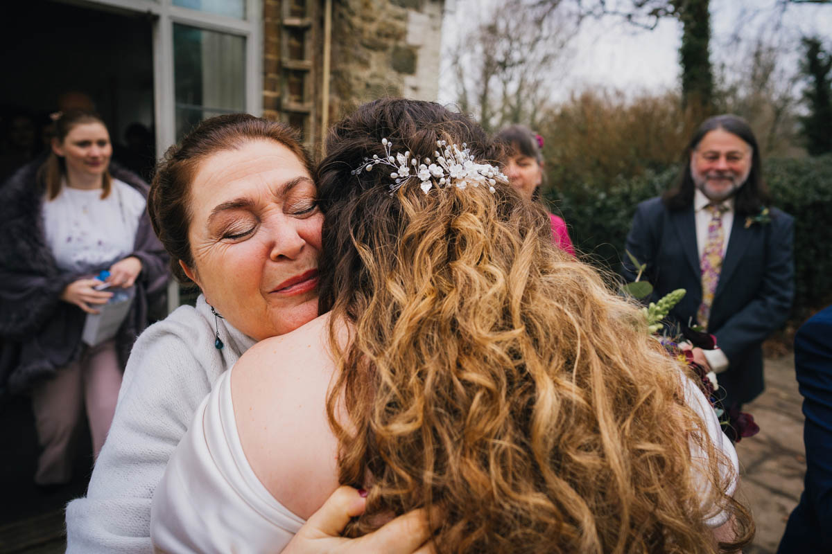 her mother hugs the bride and looks proud as she greets her after the marriage ceremony