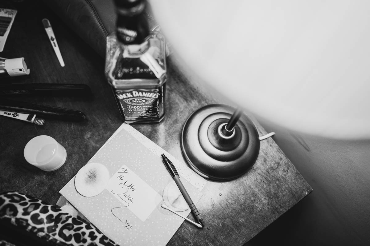 black and white photograph of a jack Daniels bottle and a wedding card addressed to the new mr and Mrs