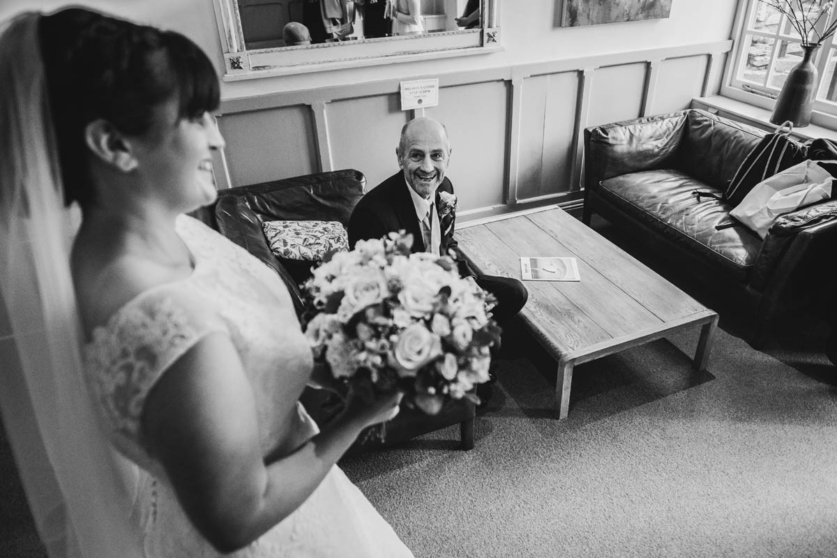 black and white photograph of the brides father's reaction to hr in her wedding dress