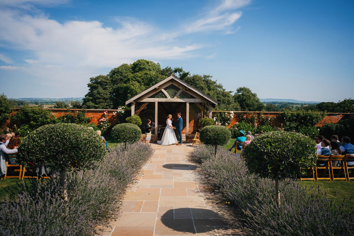 a wedding ceremony takes place in the walled garden at Upton