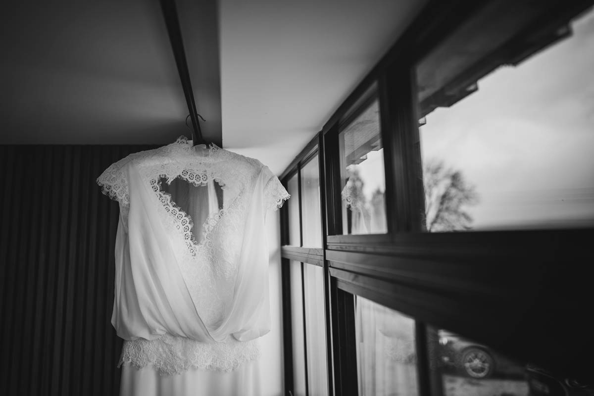 black and white photograph of the bride's wedding dress, the window frame creates lead-in lines
