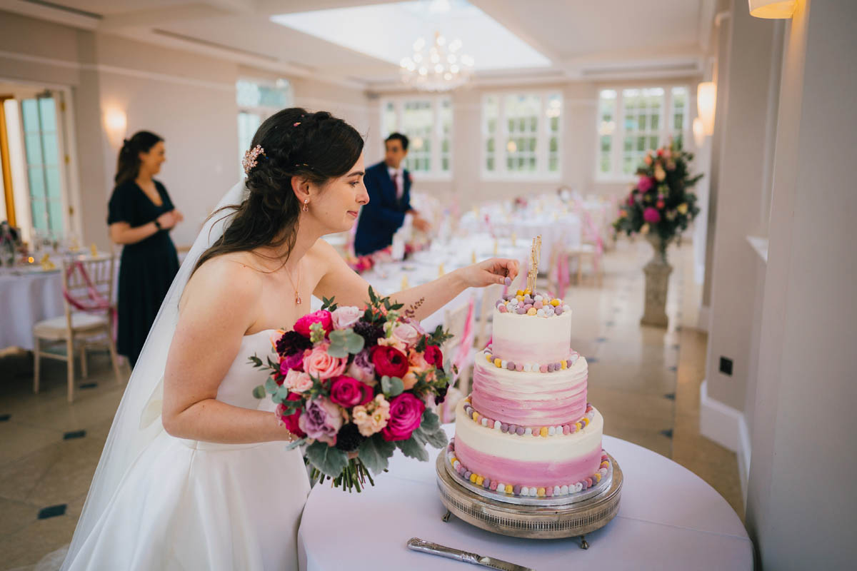 the bride takes a mini egg from the top of the wedding cake
