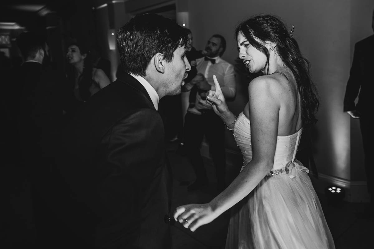 the bride shake her finger as she dances with her new husband on the dance floor