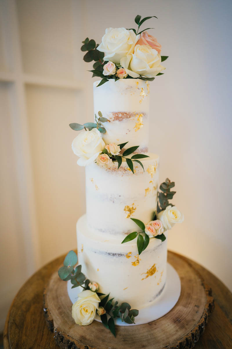 a three tiered wedding cake with flowers to decorate
