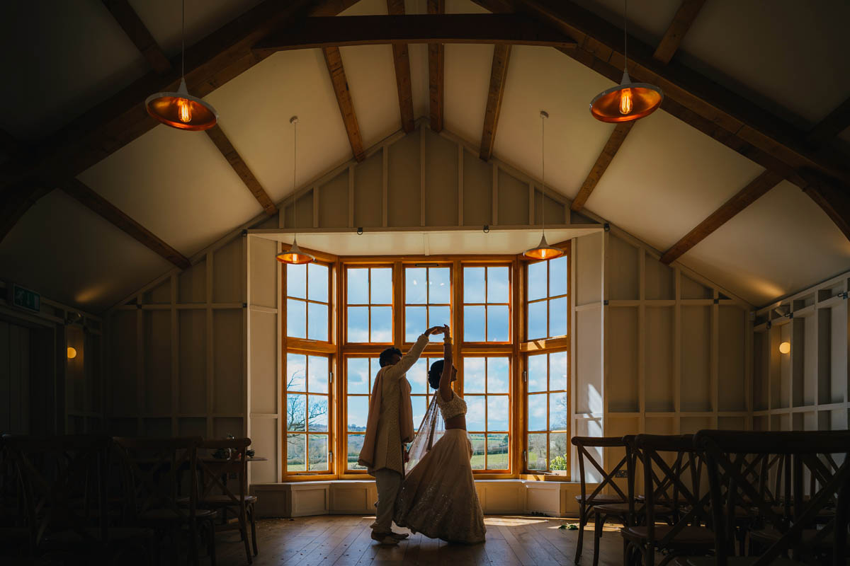 silhouette of the groom spinning his bride around in a dance in the window of the ceremony room at Hyde house
