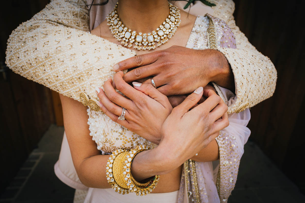 a close up of the couple holding hands in front of the bride
