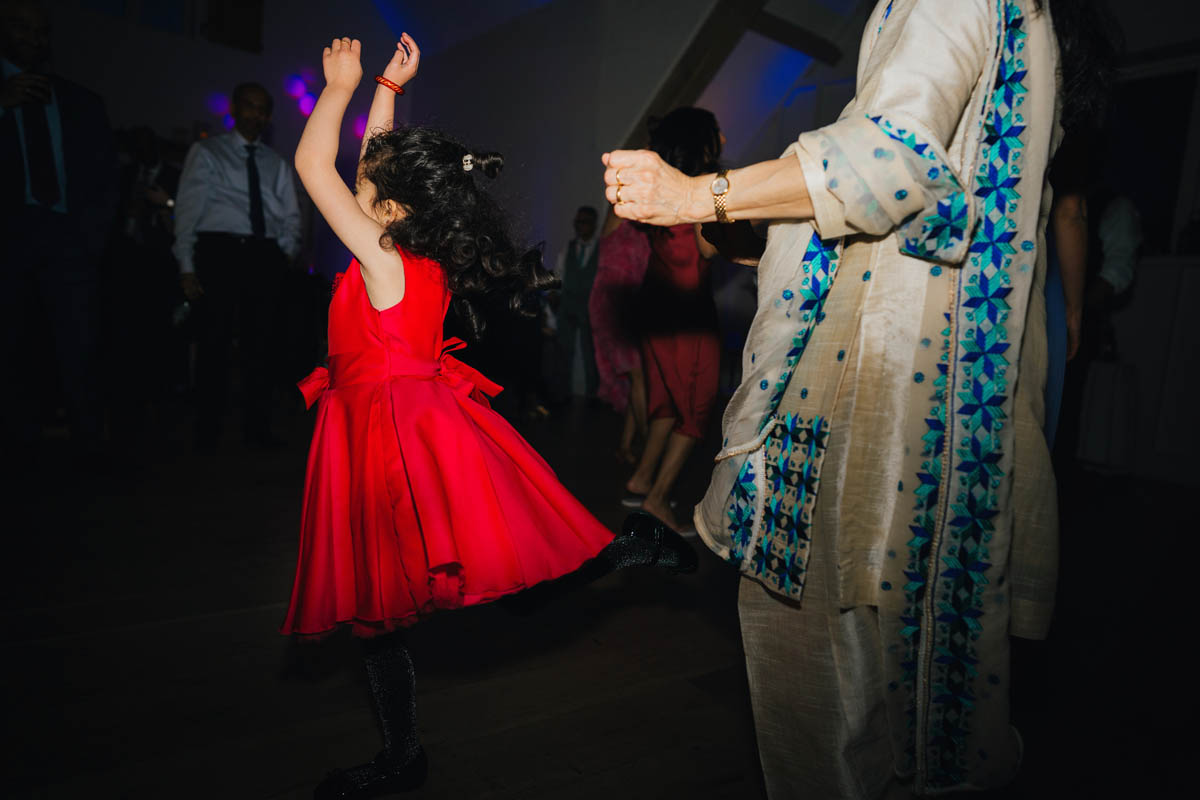 a little girl in red spins around on the dance floor