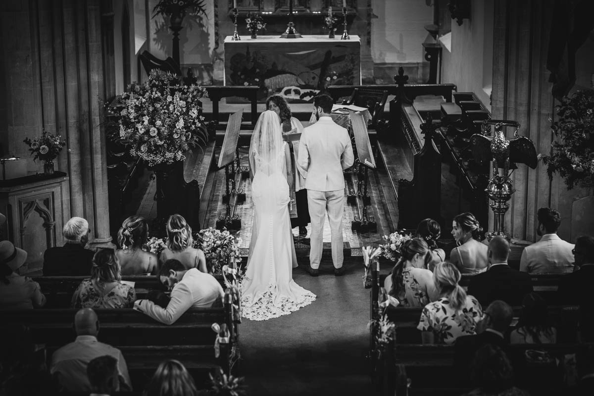 the bride and groom from behind at the church alter as they are getting married