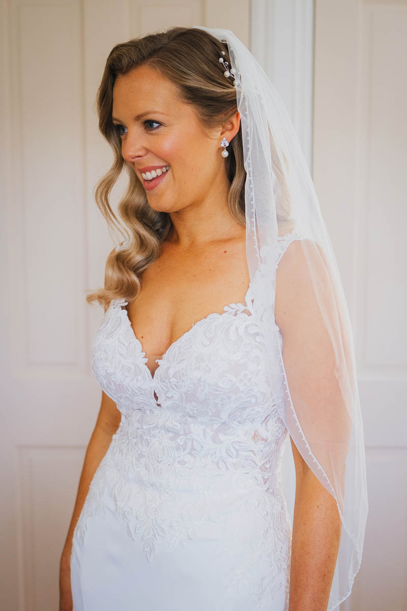 the bride in her bridal dress with a half length veil