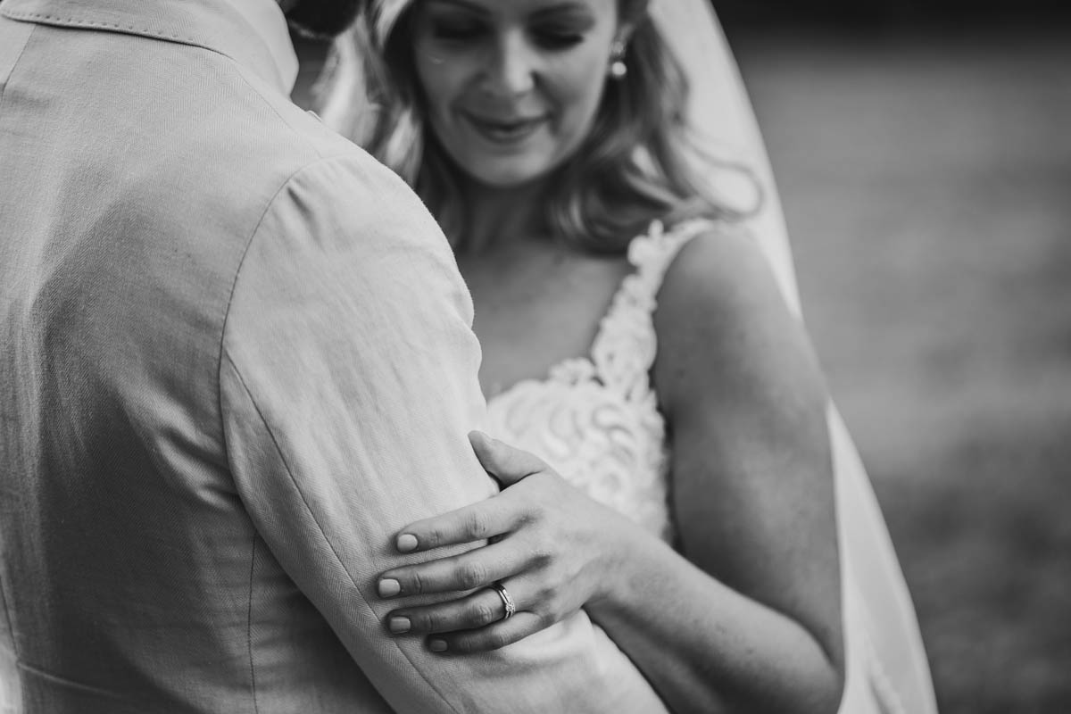 a close up of the bride hugging her new husband in black and white