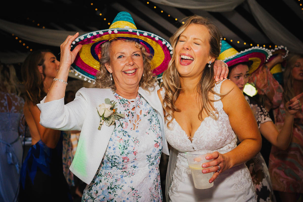the bride and her mum wearing sombreros on the dance floor