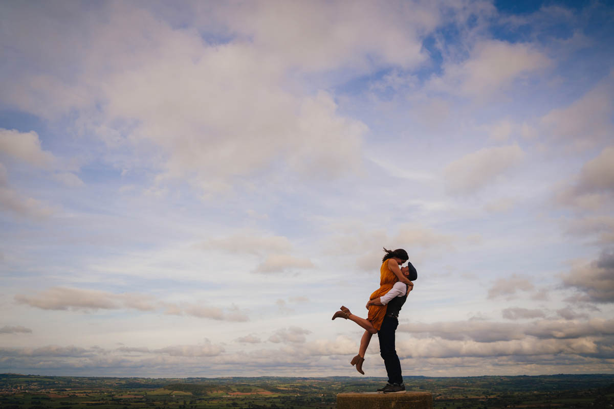 a man lifts a woman up into the sky as they kiss