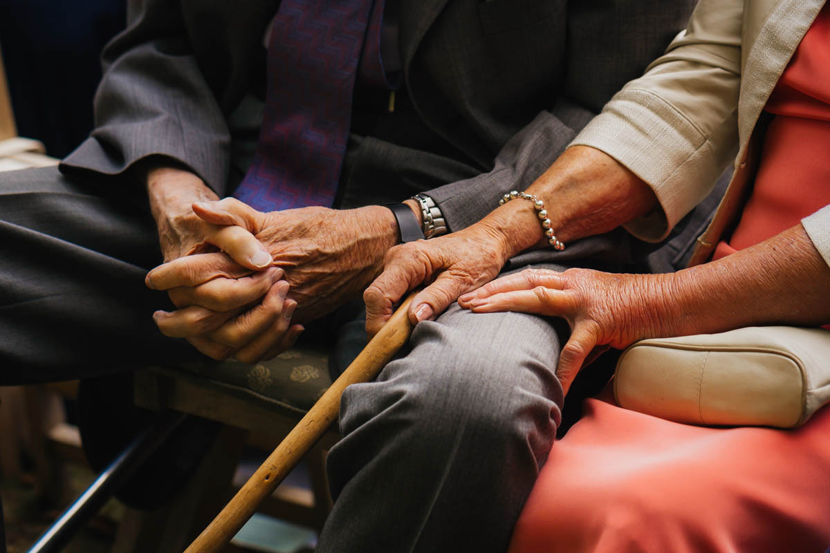 a close up photograph of an elderly couple holding hands