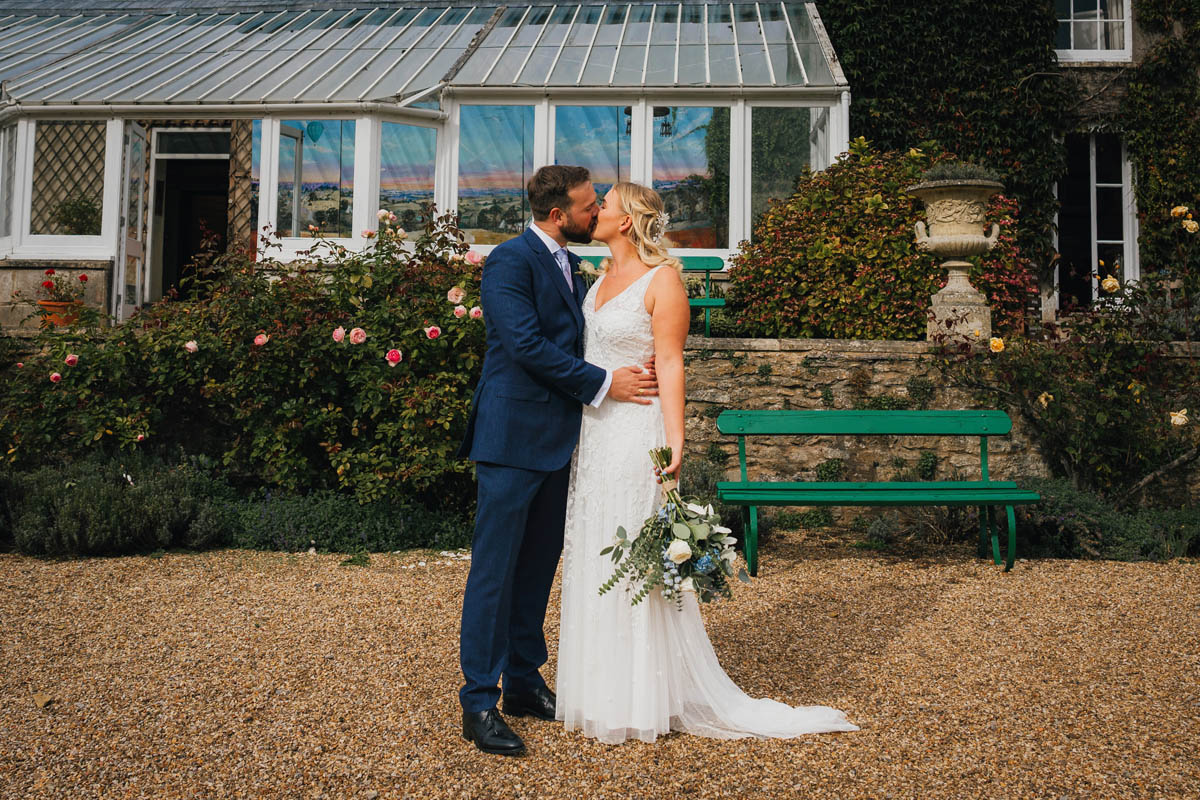 newly weds kiss in front of pennard house