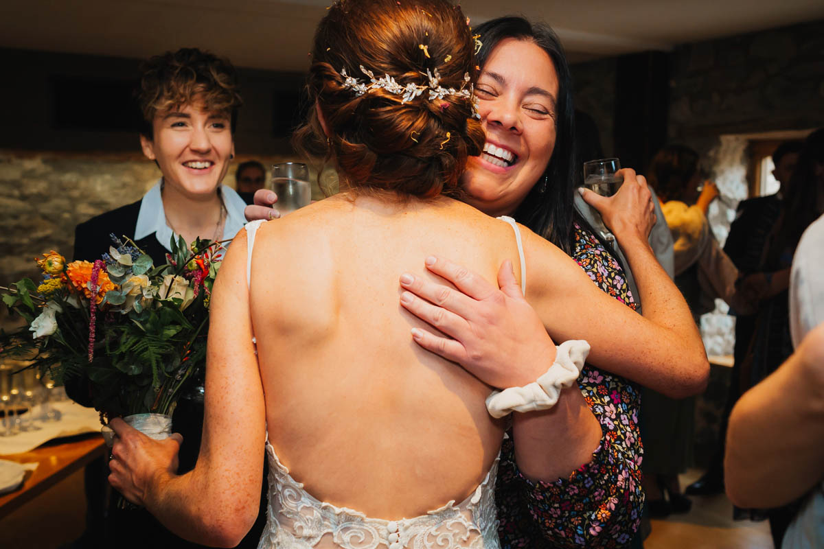 the bride hugs her friends who smile and congratulate her