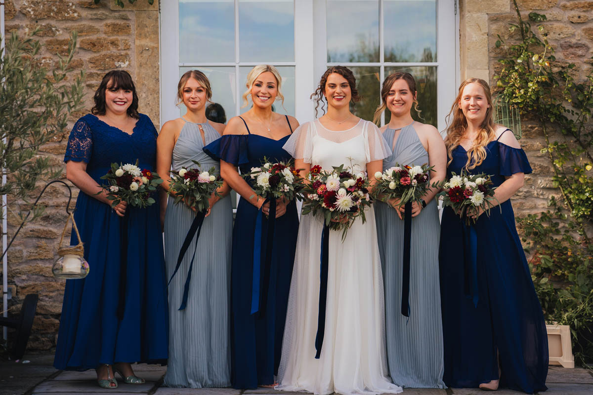 the bride and her bridesmaids hold their bouquets as they pose for the photographer