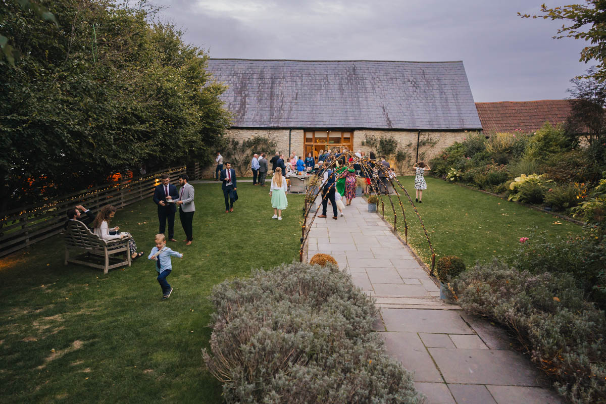 wedding guests milling around outside wick farm in the gardens