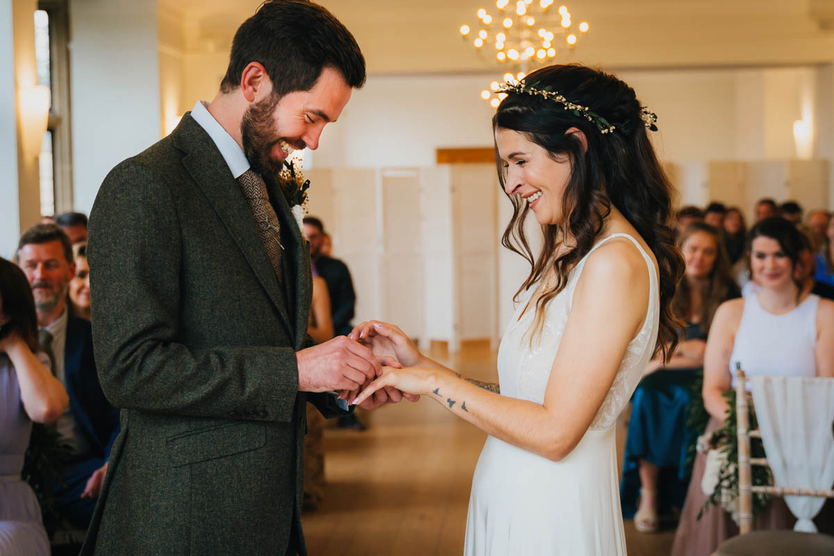 the groom places the wedding ring on his wife's finger